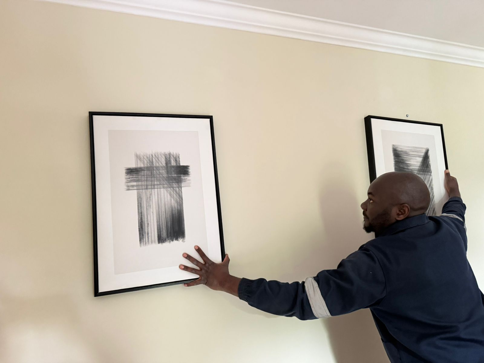 Two large framed prints hung and aligned on a wall by TIQ Group