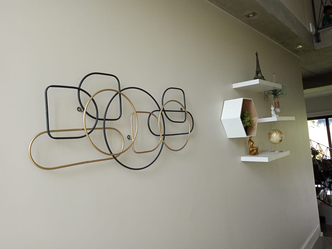 Metal wall feature and floating shelves installed on a double-volume wall